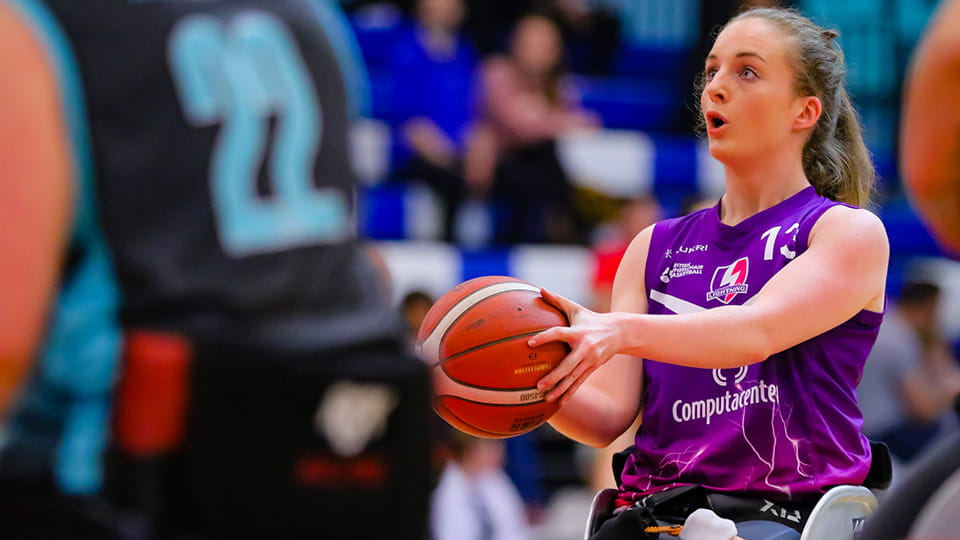 A Loughborough Lightning wheelchair basketball player holding a ball, ready to shoot