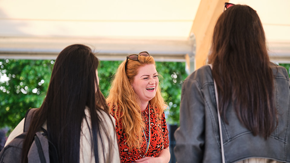 Someone laughing. Two people have their backs towards the camera.