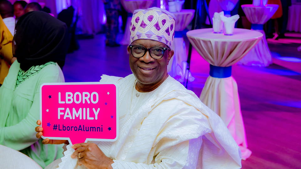 A person holding a pink Lboro Family sign