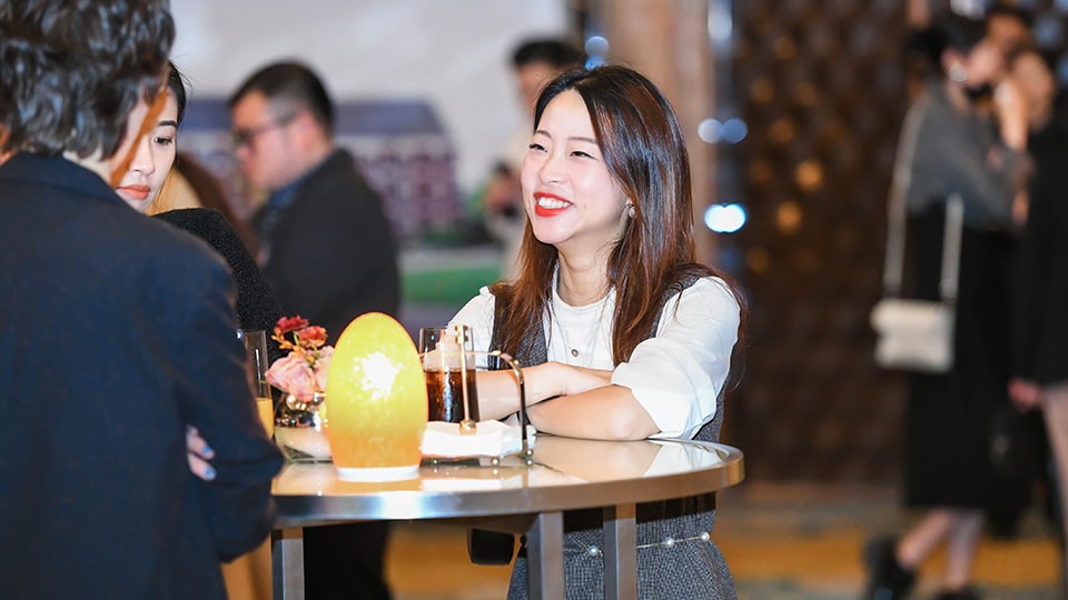 A person leaning on a table smiling at others