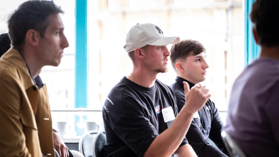 Three people. The person in the middle is talking.