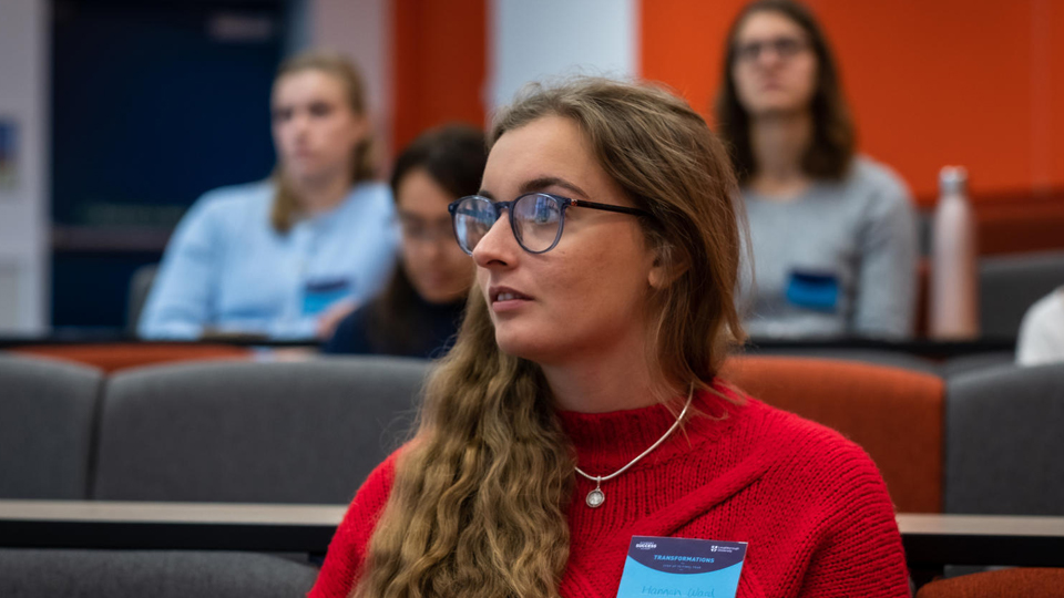 A student wearing glasses sat in a lecture room