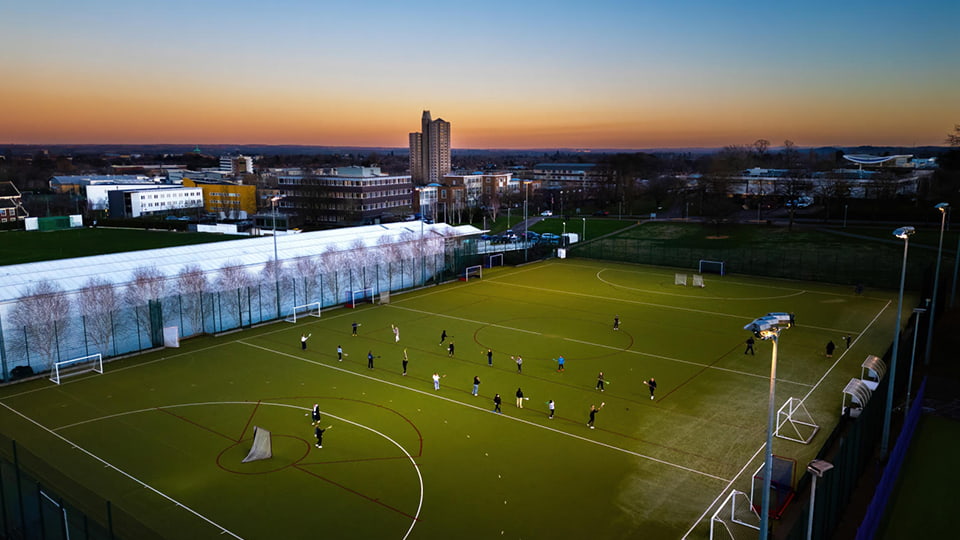 Sunrise across the campus skyline and a view of the hockey pitch