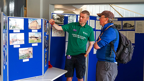 Two people looking at presentation stands that have historical images of campus on