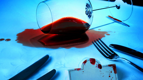 A portion of the front cover of a book. There's a spilt wine glass and cutlery.