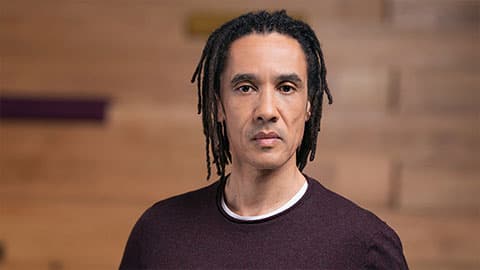 A headshot of Phil Tulba, there is a pain brown background which is blurred.