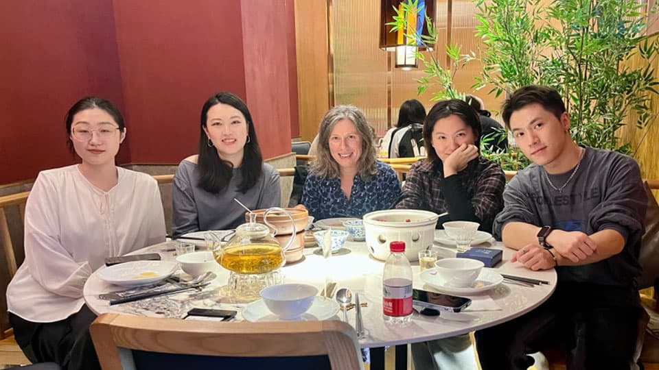 Elizabeth Peel sitting down for dinner together with four alumni at a gathering on 26th October 2024.