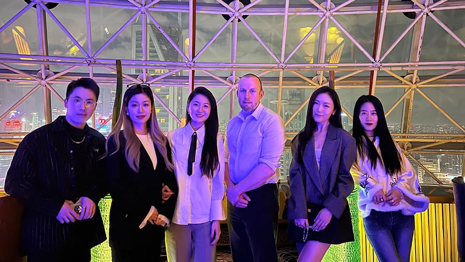 Five alumni standing smiling with Martyn Edwards, Director of Marketing and Advancement, at aa meet-up in Shanghai on 26th October 2024.