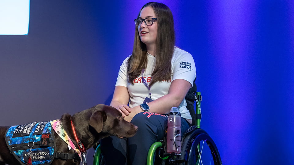 Tully Kearney wearing a GB top. Her dog is next to her.