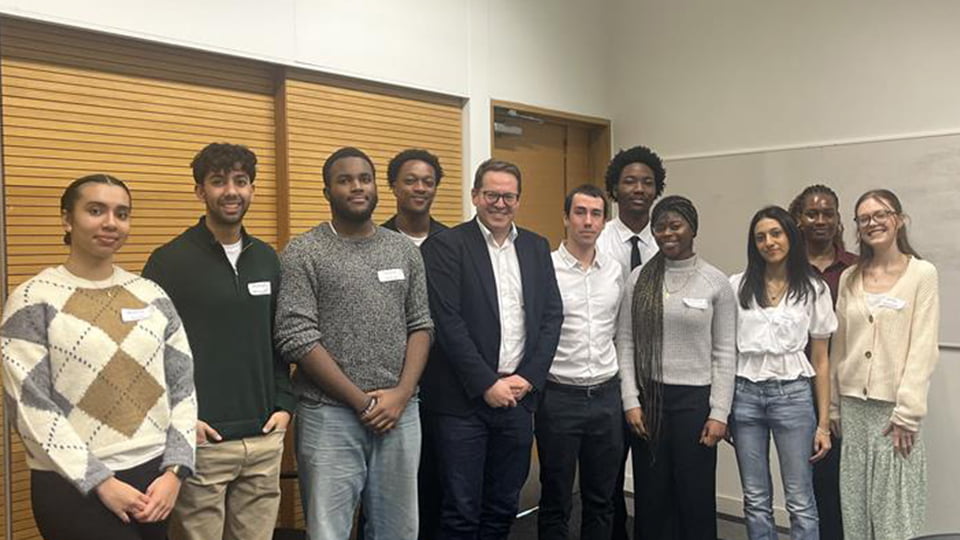 A group of students stand with Rob Maron, centre