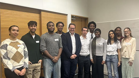 A group of students stand with Rob Maron, centre