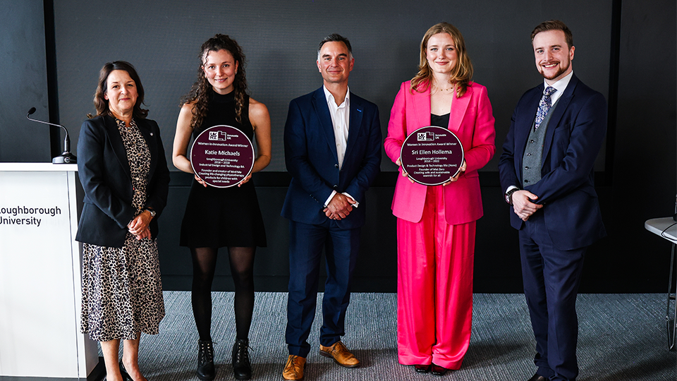 Sri and Katie holding their Purple Plaque Awards smiling at the camera with colleagues from the University