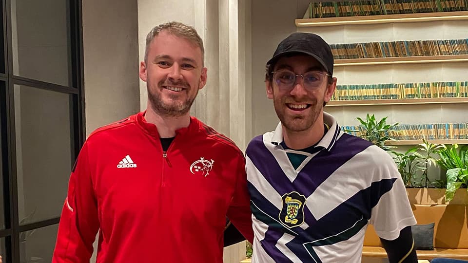 Two people wearing sports clothes, smiling.