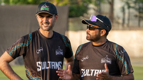 Gohar standing with another person, wearing Sultans tops and caps