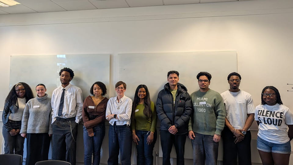 Lara, centre, with students standing each side in a lecture room