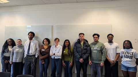 Lara, centre, with students standing each side in a lecture room