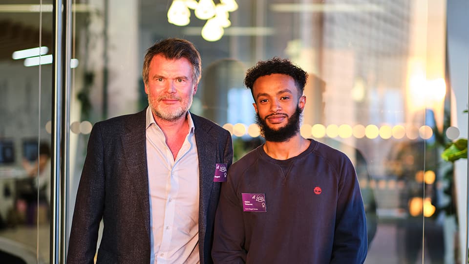 An alumnus and a scholar stand together