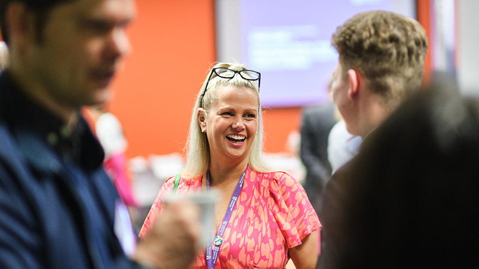 A person smiling at someone else whose back is towards us