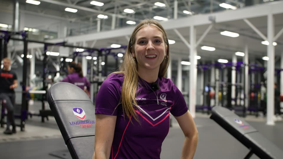 Student Jess in a Loughborough Sport top, smiling in the gym