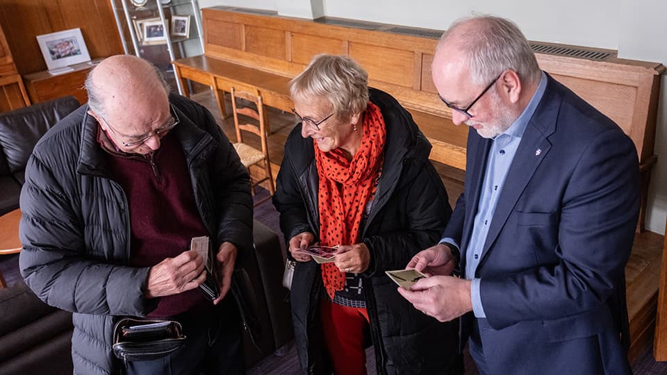 Three people looking at photographs