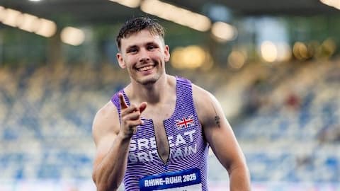 Harry wearing a GB vest, smiling and pointing