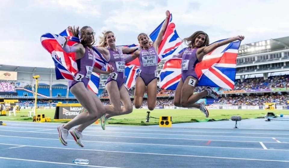 Four athletes with GB flags jumping in the air