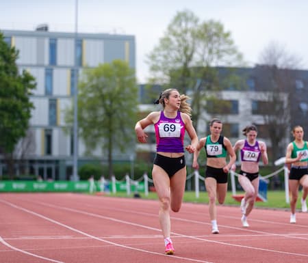 Jess running on an athletics track