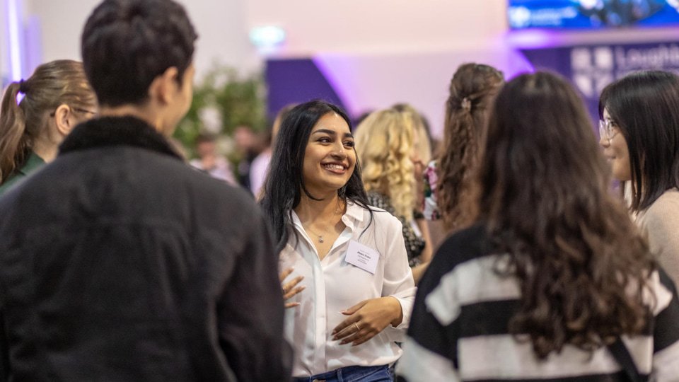 A student is in the centre smiling amongst a group of other students