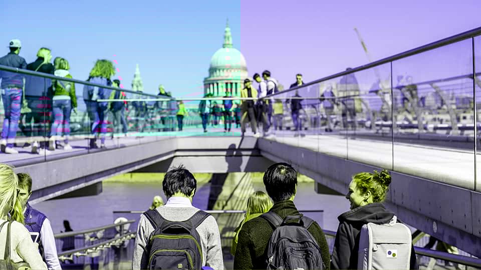 crowds of people on the Millennium Bridge walking towards St Paul's cathedral in London