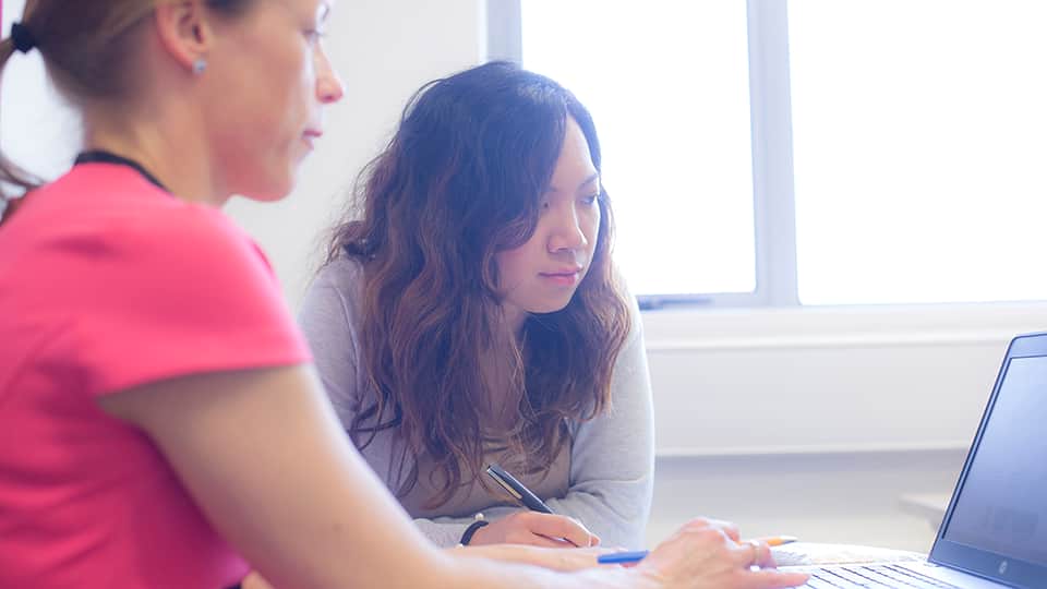 two women looking at a laptop screen