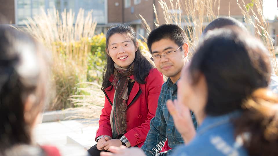 a group of students sitting outside talking