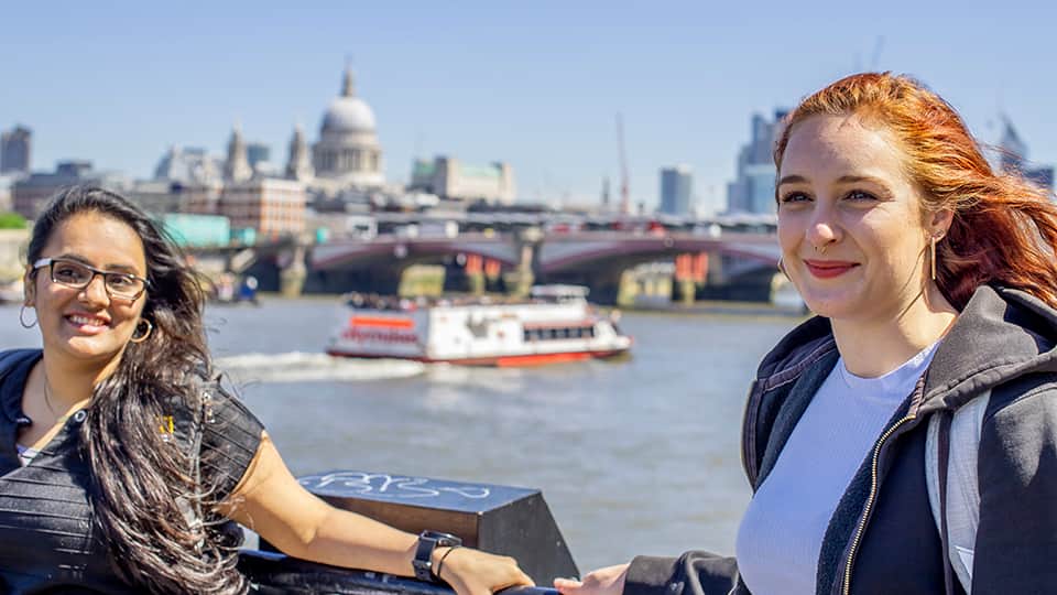 two women standing on a bridge over the river Thames, St Paul's cathedral in the background