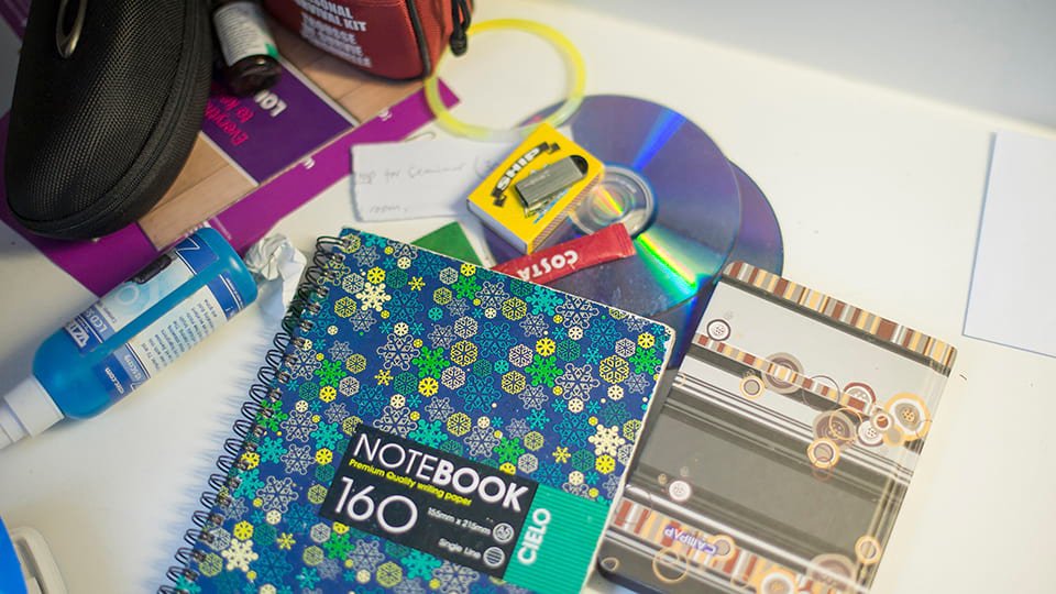 a notebook, pen, post it note and mug of coffee on a table