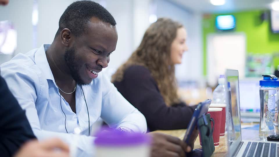 two people sitting at desks using computers