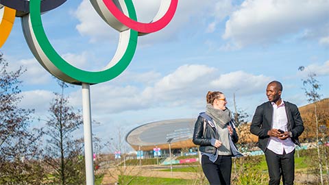 Two students walking through Queen Elizabeth Olympic Park, London