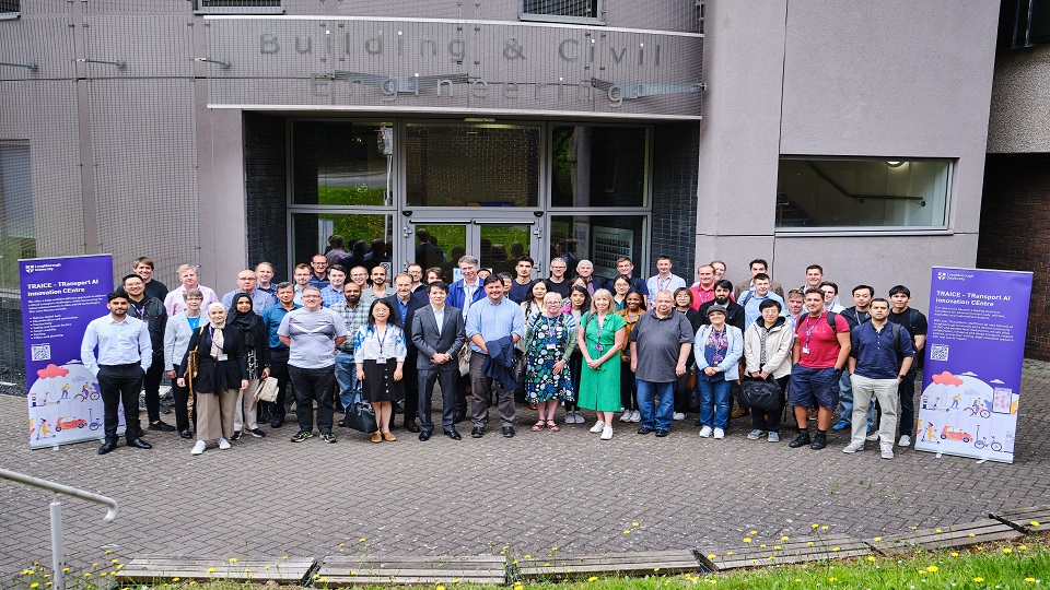 The academics of TRAICE pose for a photo outside the Frank Gibb building at Loughborough University.