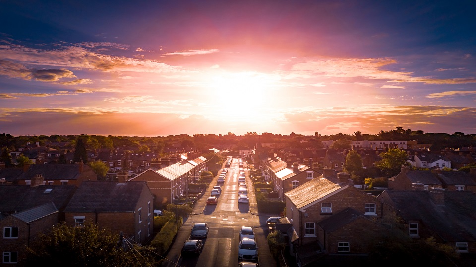 An aerial shot of a typical British street with the sun in the background