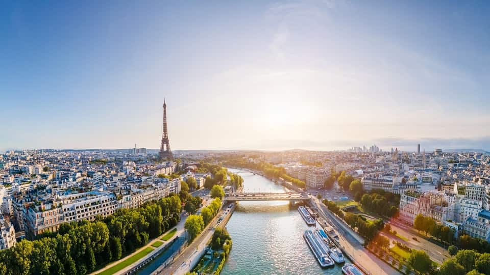 An aerial shot of the River Seine in Paris. The Eiffel Tower can be seen to the left.