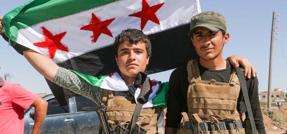 Fighters flying the Syrian flag