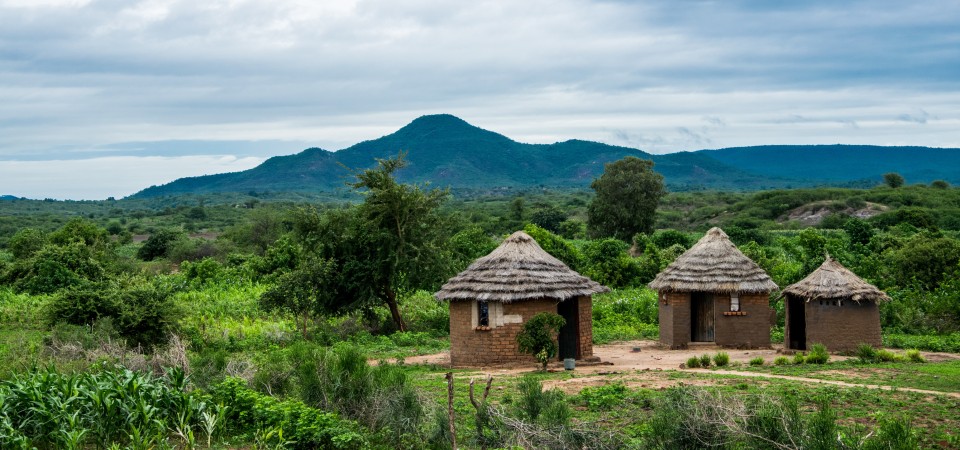 rural Zimbabwe mountains in the background three huts in the foreground