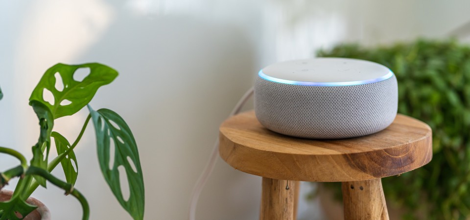 An Alexa device sitting on a wooden stool