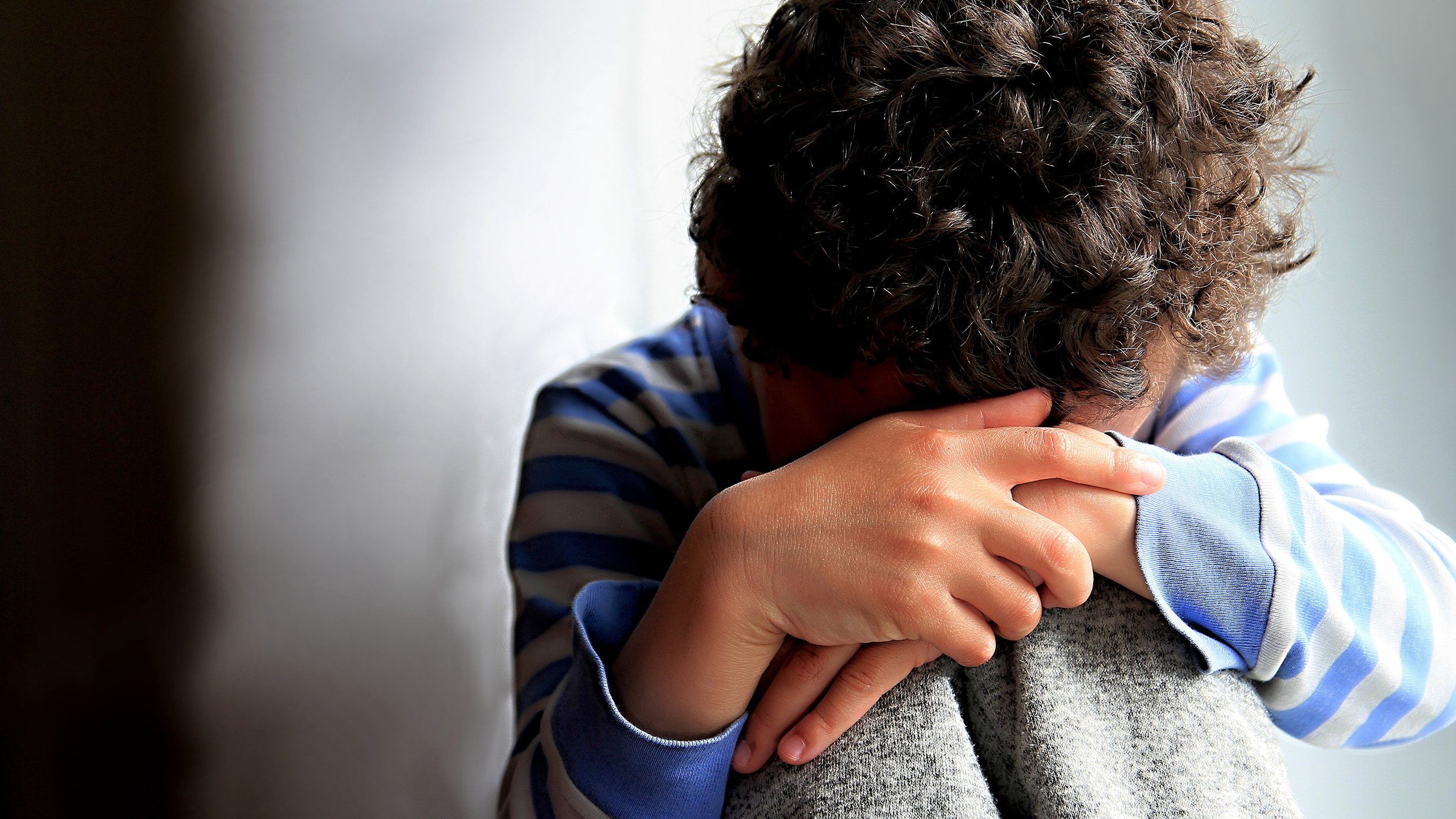 child sat with head in hands