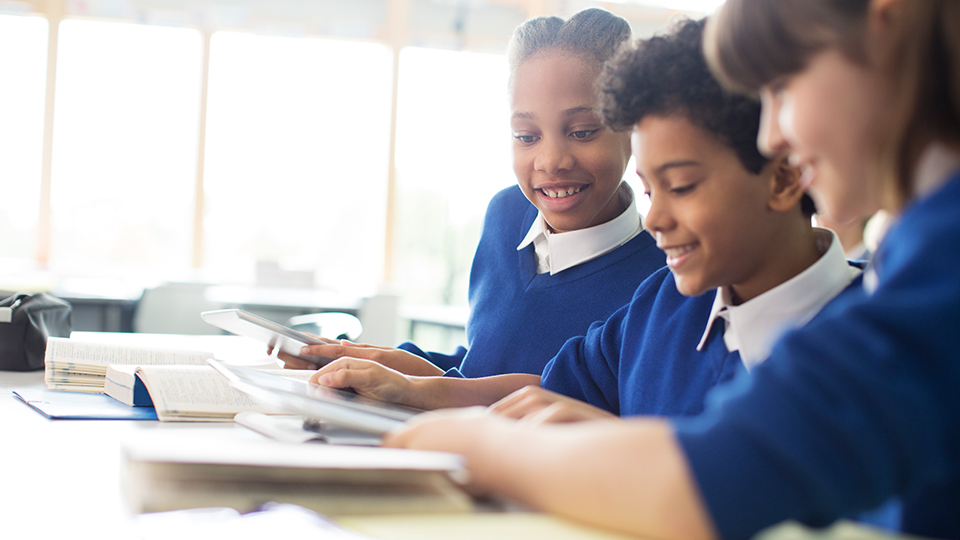 3 children sat working together at school