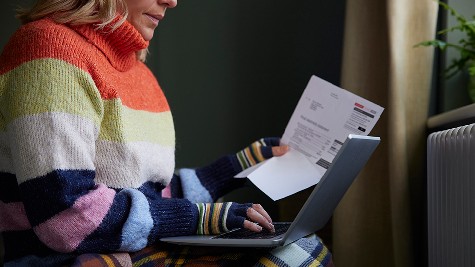 Woman checking bill sat wrapped up warm