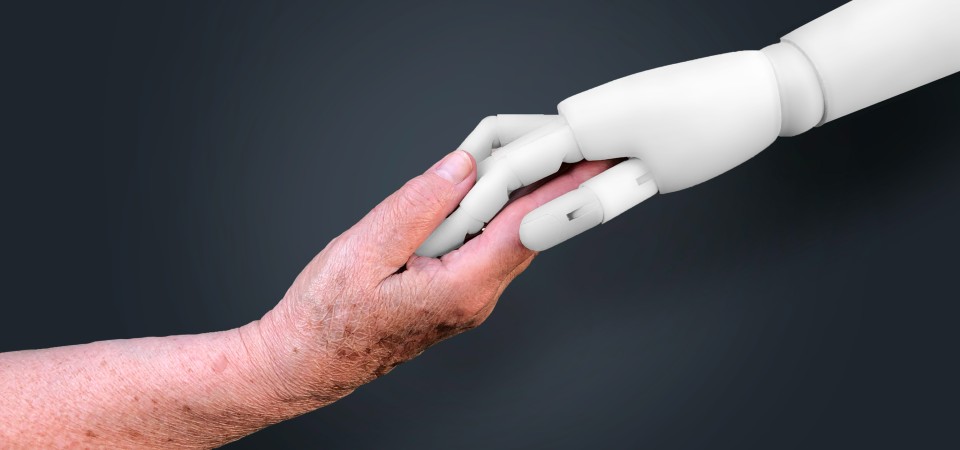 a human hand holding a robot hand