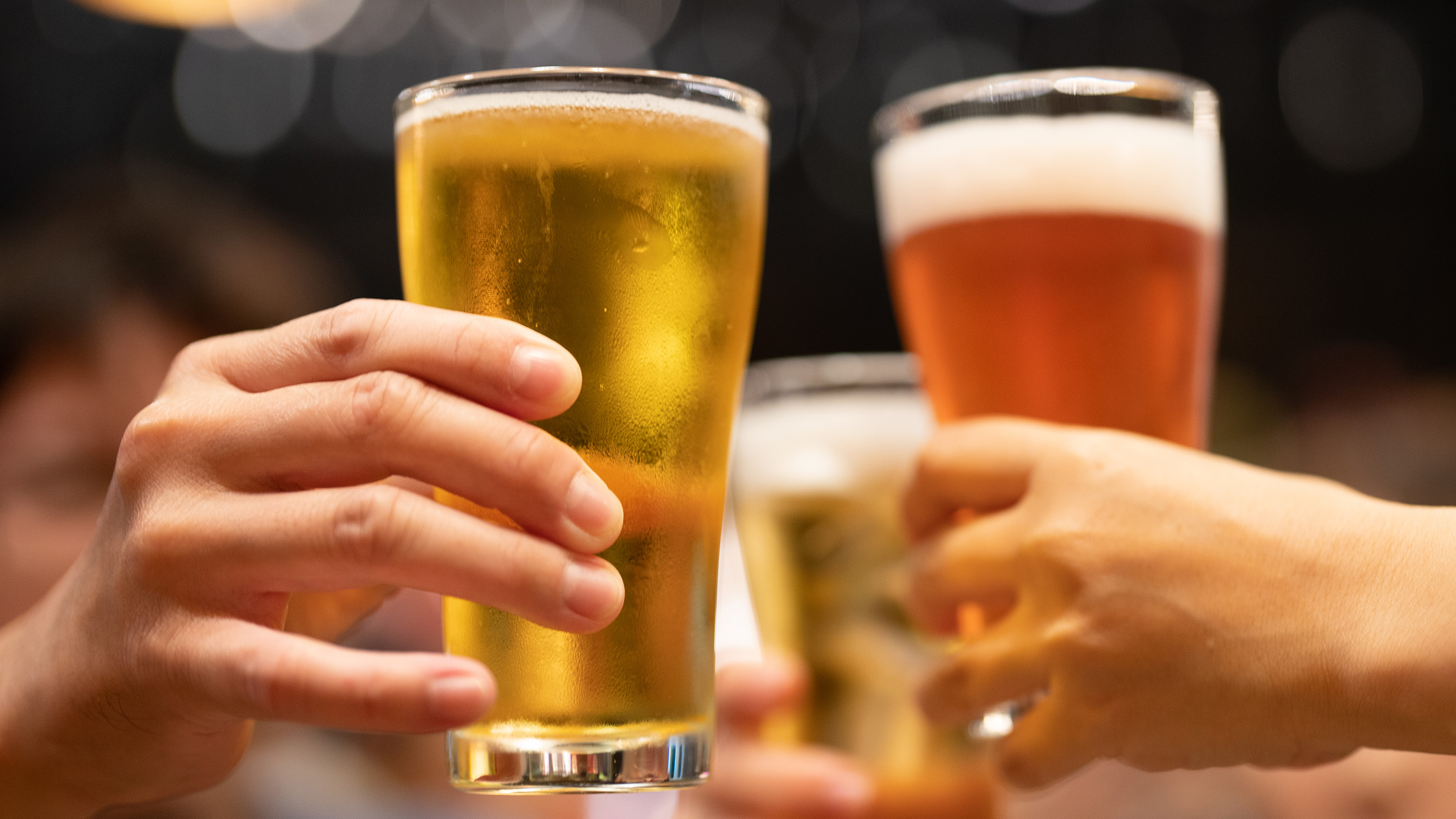 Two glasses of beer being held up