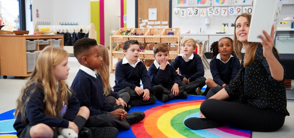Primary age children sitting around a teacher