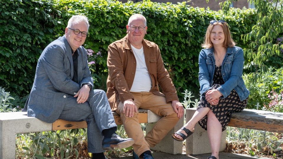 Dr Rob Harland, Professor Mike Wilson and Dr Catherine Rees are sat together on a bench outside.