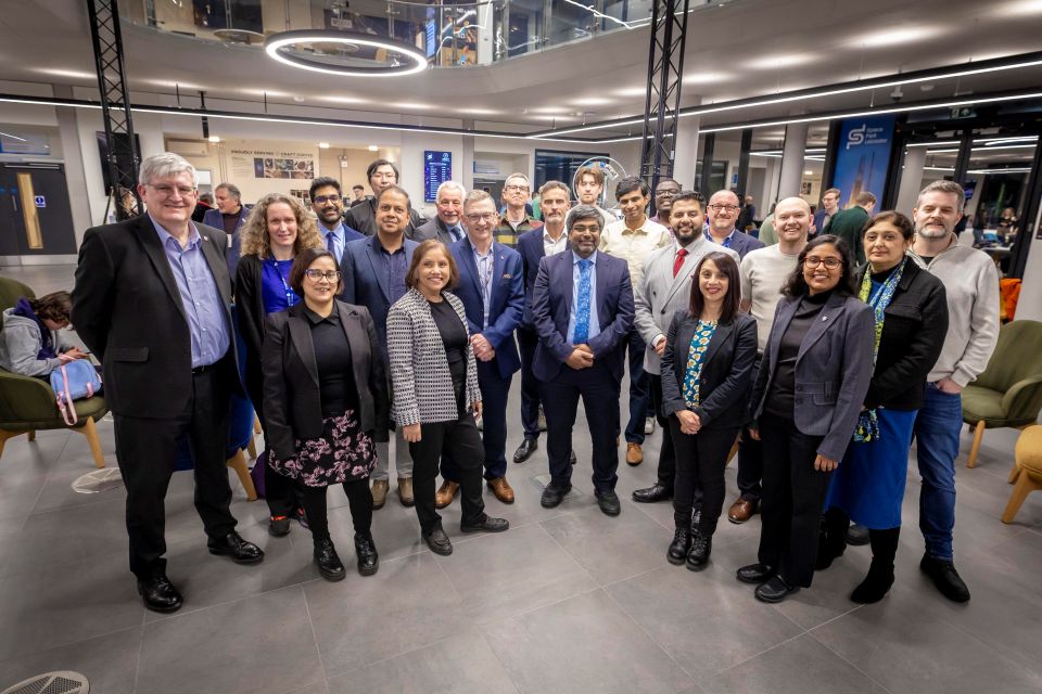 A group of academics are gathered in a science lab celebrating the award shortlist
