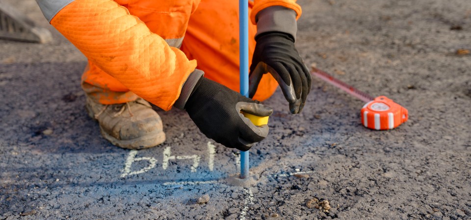 A man plots out markings on a road